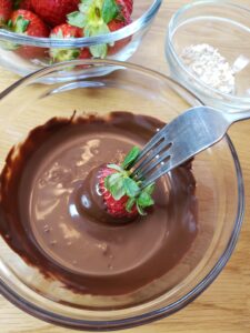 dipping strawberry into chocolate