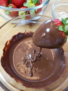 dipping strawberry into chocolate